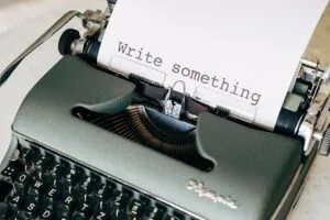 Máquina de escrever com texto "write something" datilografado